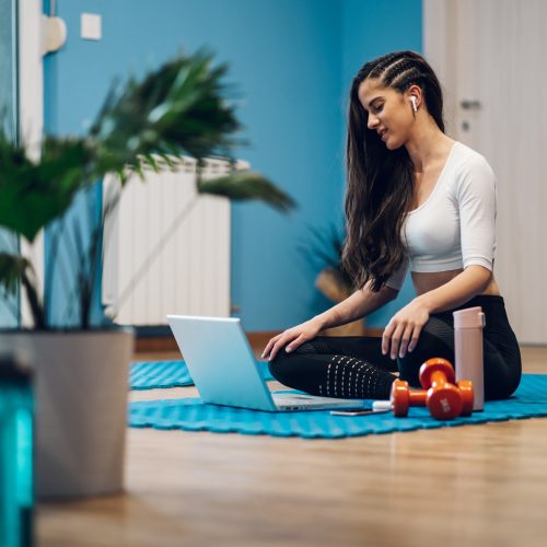 Woman training at home and coaching an online fitness routine